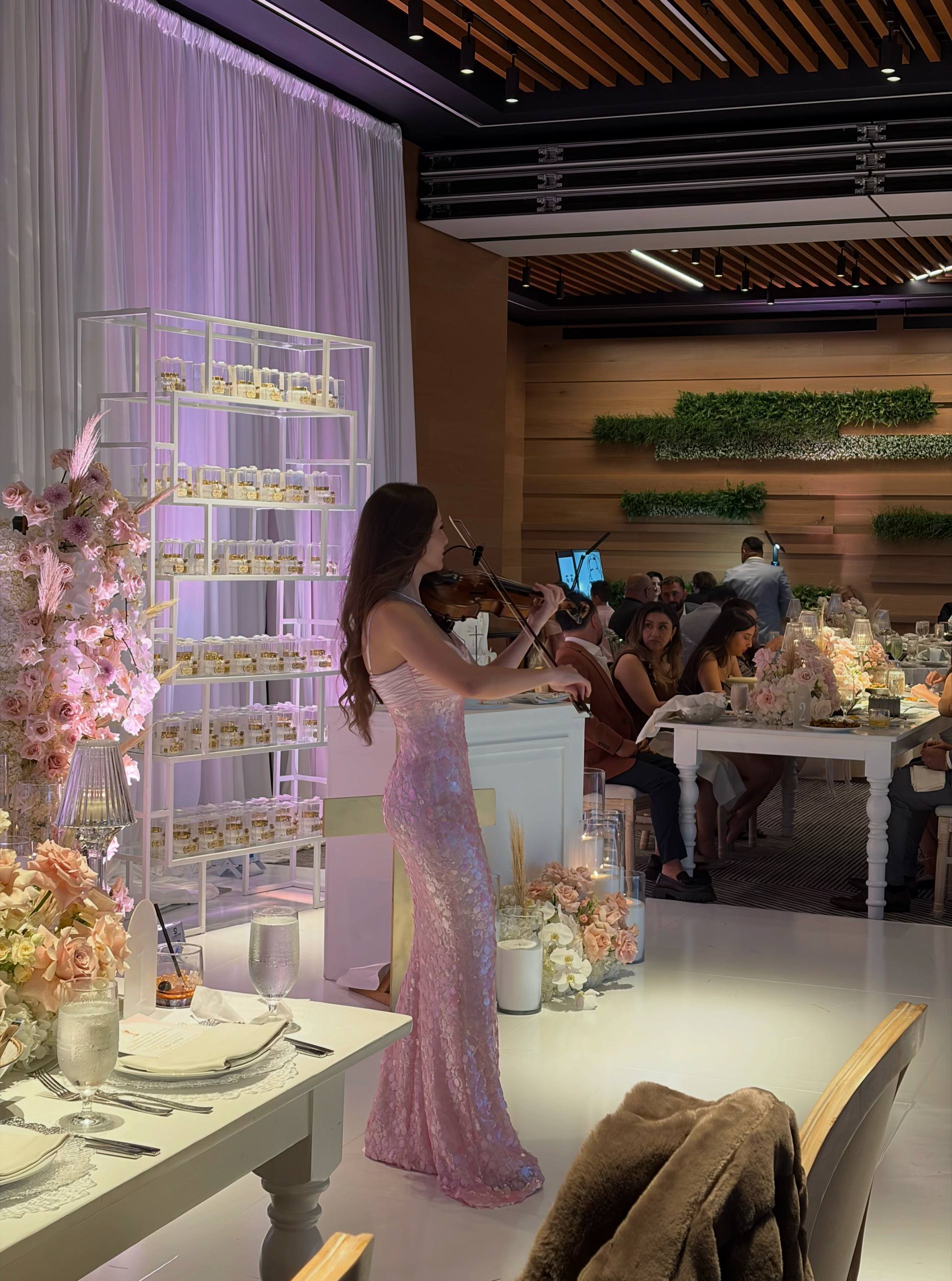 Tatev Muradyan in a sequined gown playing violin at an elegant dinner reception