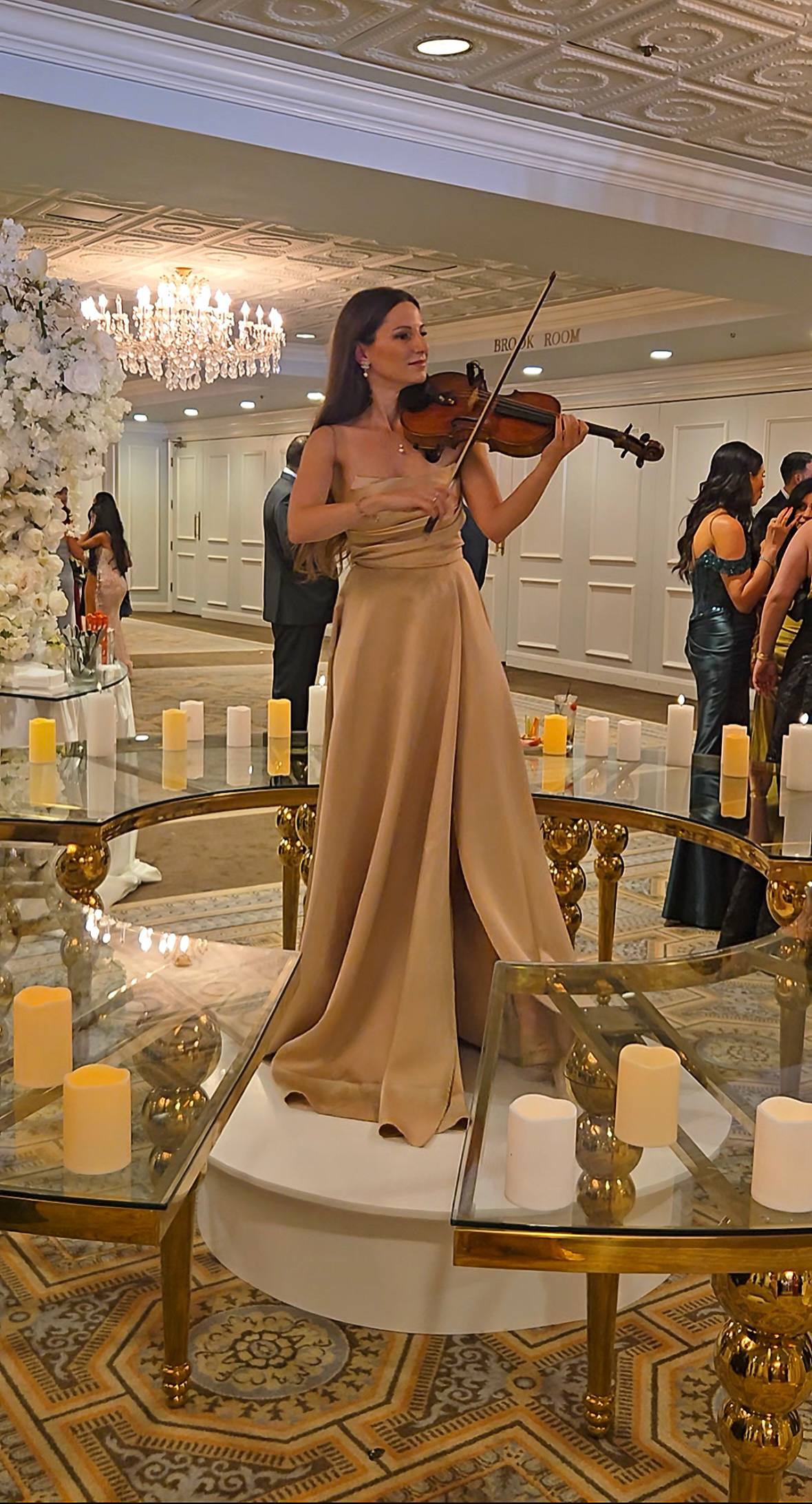 Tatev Muradyan performing among candlelit tables at a reception