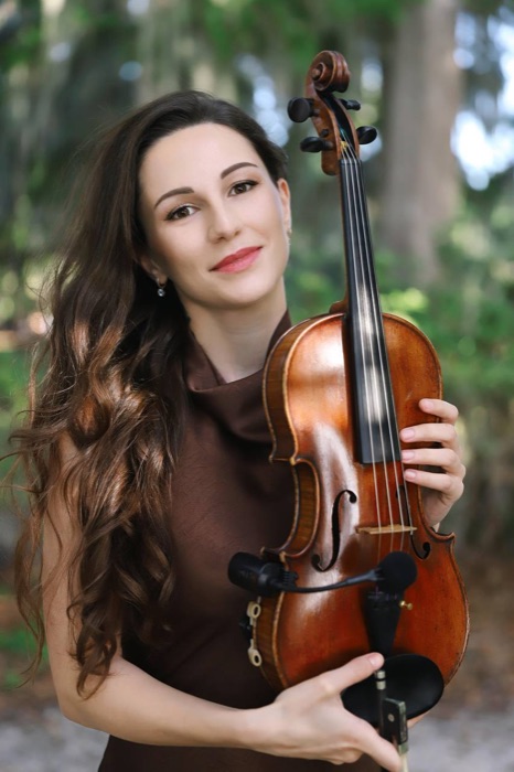 Portrait of Tatev Muradyan holding her violin outdoors
